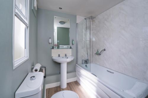 La salle de bains est pourvue d'un lavabo, de toilettes et d'une baignoire. dans l'établissement Ye Olde Griffin, à March