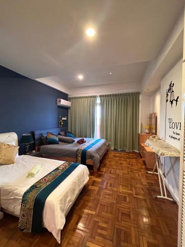 a hotel room with two beds and a couch at Riverbank suites waterfront in Kuching