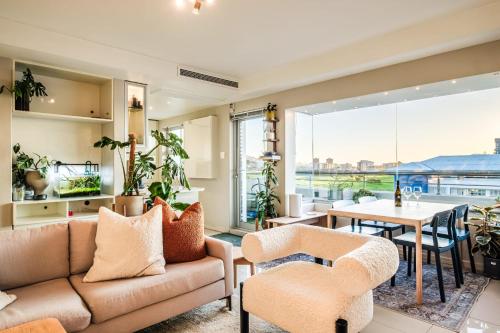 a living room with a couch and chairs and a table at The Apartment in Mouille Point in Cape Town