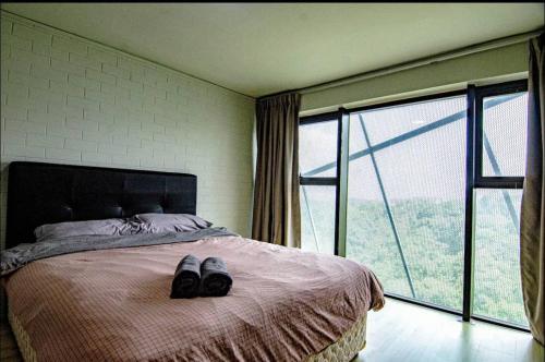 Un dormitorio con una cama con un par de zapatos. en Bathtub Soho, Forest View Empire Damansara, en Petaling Jaya