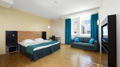 pokój hotelowy z łóżkiem i kanapą w obiekcie Hestia Hotel Seaport Tallinn w Tallinnie