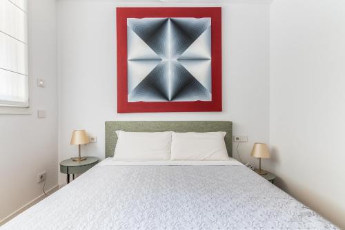 een slaapkamer met een bed en een schilderij aan de muur bij [Residenza Il Princype] Appartamento di Lusso in Milaan