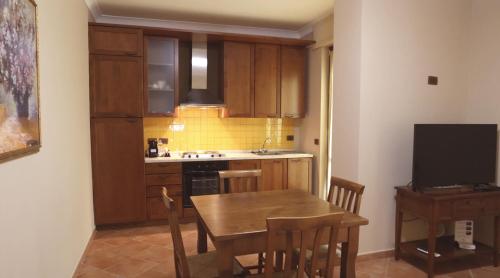 uma cozinha com uma mesa de madeira e uma sala de jantar em RESIDENCE VITTORIA em Acri
