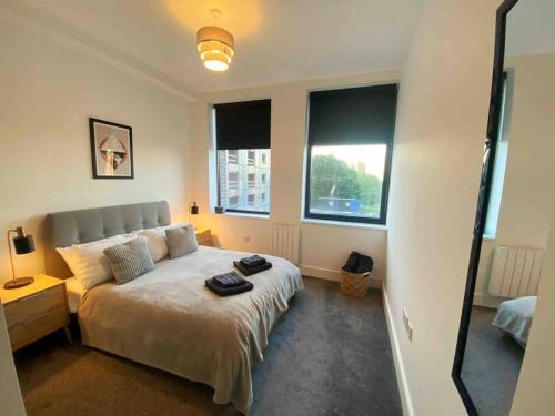 a bedroom with a large bed with a large window at Beautiful 1 Bed Flat near NEC with secure parking in Birmingham