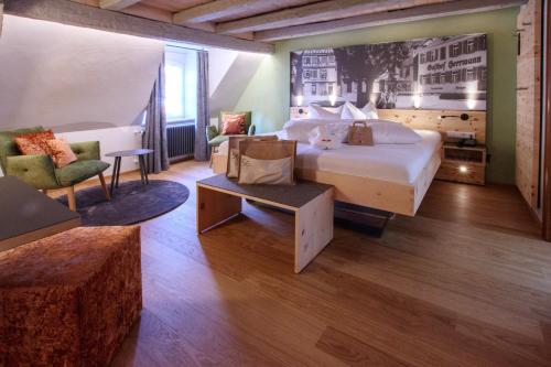 a hotel room with a large bed and two chairs at Hotel Herrmann in Münsingen