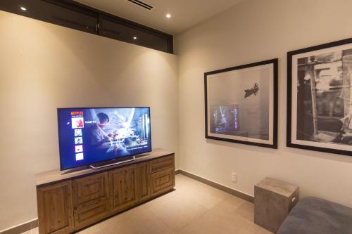 a living room with a flat screen tv on a wall at Faru Beachfront Villa Sanctuary Ho Tram in Ho Tram
