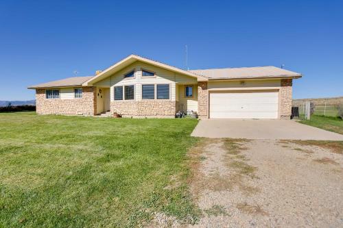 a brick house with a garage in a yard at Cortez Retreat with Office and Stunning Mtn Views in Cortez
