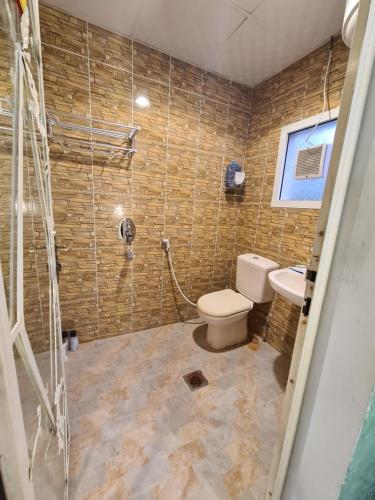 ein Bad mit einer Dusche, einem WC und einem Waschbecken in der Unterkunft amazing view large dunes nearby in Liwa