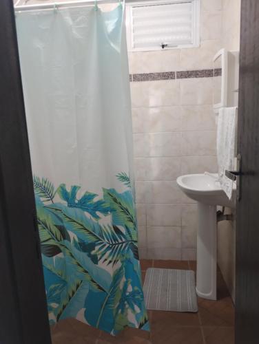 a bathroom with a shower curtain with a sink at Praiana in Guaratuba