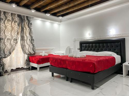 - une chambre avec 2 lits dotés de draps rouges et de rideaux dans l'établissement Relais Parlamento, à Rome
