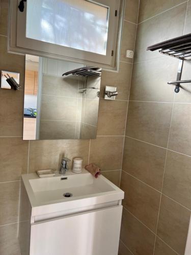 une salle de bain avec un lavabo blanc et un miroir dans l'établissement Cocon à la montagne, à Montclar