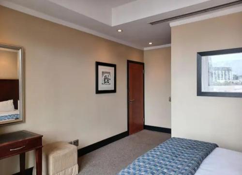 Schlafzimmer mit einem Bett, einem Spiegel und einem Schreibtisch in der Unterkunft Luxurious apartments in Johannesburg