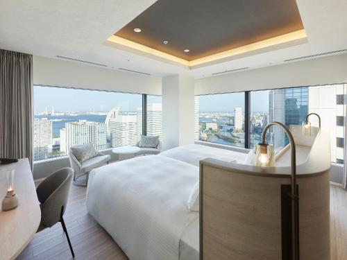 - une chambre avec un grand lit et une grande fenêtre dans l'établissement Mitsui Garden Hotel Yokohama Minatomirai Premier, à Yokohama