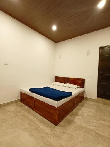 a bedroom with a bed with a blue blanket at Paradise Homestay in Wayanad