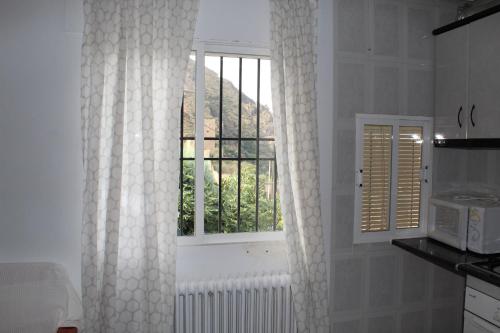 a white kitchen with a window and a radiator at Casa La Azotea de Cazorla in Cazorla