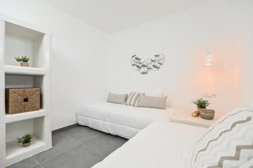 a white room with two beds and a couch at White Cocoon Exclusive villas in Naxos Chora