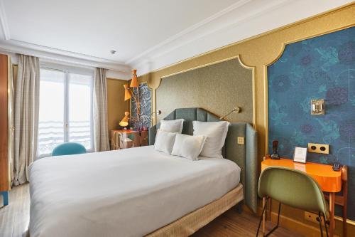 a hotel room with a bed and a desk and a bed at Idol Hotel in Paris