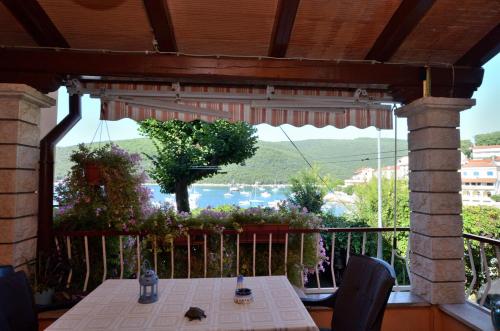 a table on a balcony with a view of the water at App Lori in Rabac