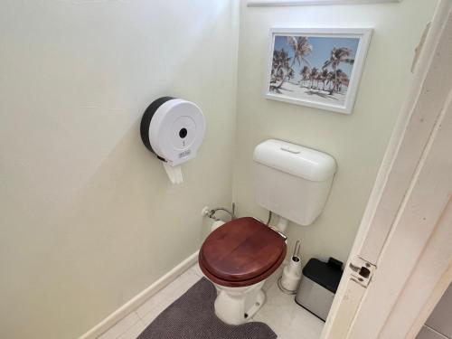 a bathroom with a toilet with a wooden seat at Cosy Homes - 15 Minutes Away From Melbourne Airport in St Albans