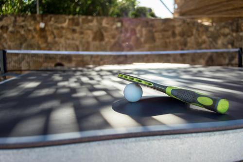 a tennis racket and ball on a tennis court at Villa Eleftheria, Lakithra - Spacious luxury villa with pool and stunning views in Lakithra