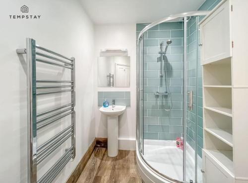 La salle de bains est pourvue d'une douche en verre et d'un lavabo. dans l'établissement COSY HOME IN CENTRAL WINDSOR & FREE PARKING, à Windsor