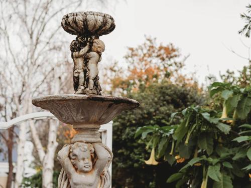 a statue of a boy on a fountain at Le Petit Paris in Franschhoek