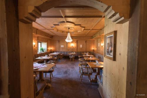uma sala de jantar com mesas e cadeiras de madeira em B&B Villa Stelvio em Sta Maria Val Müstair
