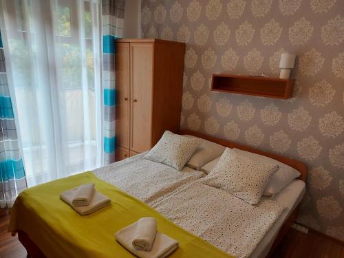 a bedroom with a bed with two slippers on it at Noclegi Zwycięstwa 34A in Międzyzdroje