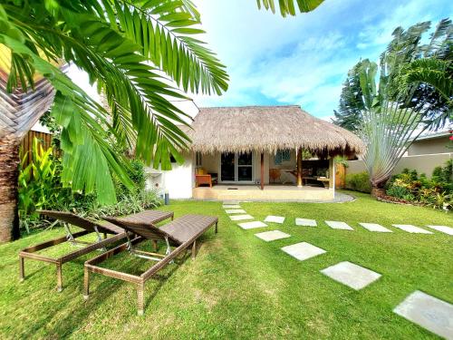 a garden with two benches and a house at Halamanan Residences in Panglao