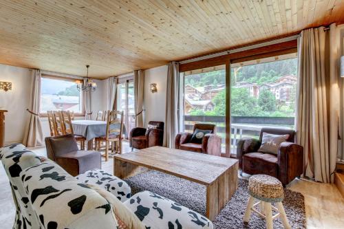 ein Wohnzimmer mit einem Sofa, Stühlen und einem Tisch in der Unterkunft Le Jangilau in Morzine