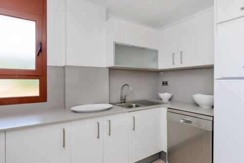 a white kitchen with a sink and a window at Tossa dreams in Tossa de Mar