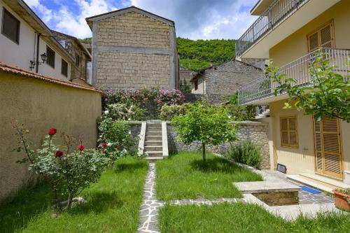 a garden with stairs and flowers in front of a building at Orsini: tre camere da letto, 2 bagni in Luco dei Marsi