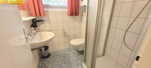 ein Bad mit einem WC, einem Waschbecken und einer Dusche in der Unterkunft Bungalow Irmgard by FiS - Fun in Styria in Bad Mitterndorf