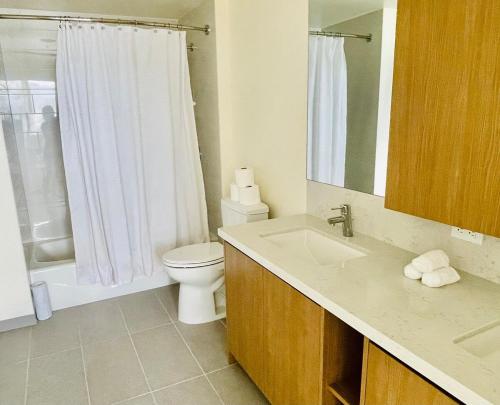 a bathroom with a sink and a toilet and a shower at Semprose Central Ala Moana in Honolulu