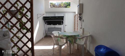 uma mesa e cadeiras num pequeno quarto com uma janela em Mandriola Putzuidu Capo Mannu em Putzu Idu