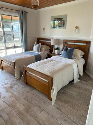 een slaapkamer met 2 bedden en een raam bij Serenity by the Sea Cottage in Apollo Bay with Jacuzzi in Marengo