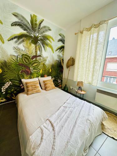 a bedroom with a bed with a palm tree mural at Studio Bohème hypercentre in Amiens