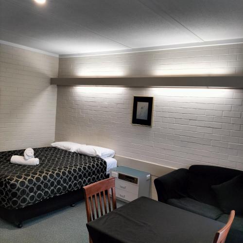 a hotel room with a bed and a couch at Wangaratta Motor Inn in Wangaratta