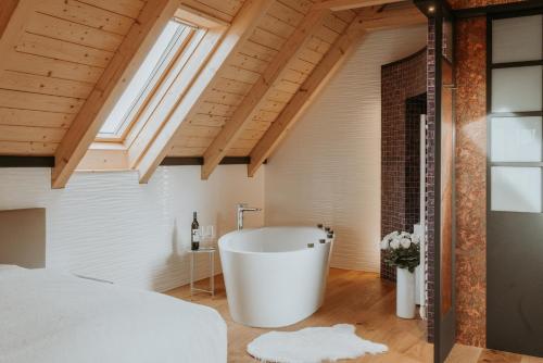 - une salle de bains mansardée avec une grande baignoire dans l'établissement Living & Relax Resorts, à Sausal