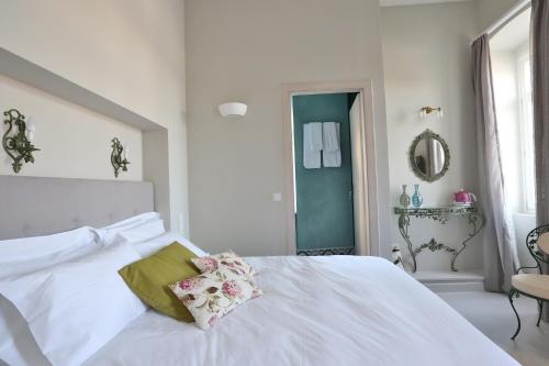 a white bed with a pillow on it in a bedroom at 1901 Hermoupolis in Ermoupoli