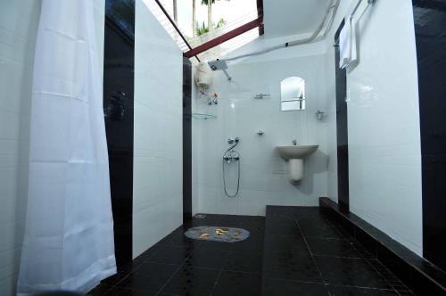 a bathroom with a toilet and a sink in it at The Lake by Maat Hotels in Alleppey