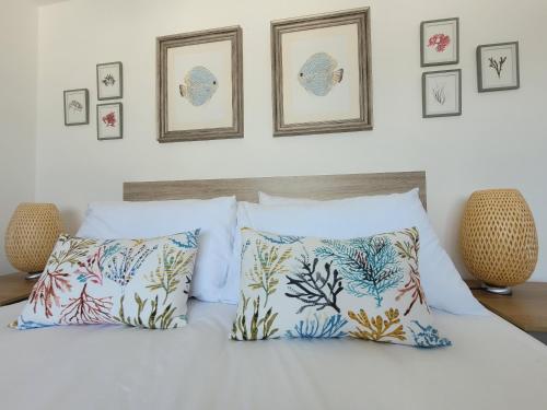 a bedroom with a bed with pillows and pictures on the wall at No. 28 Contemporary beach side property with sea views in Chichester