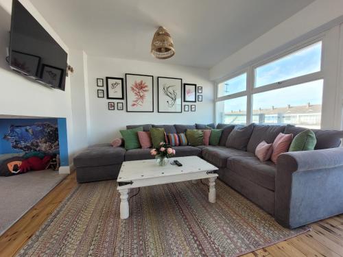 a living room with a couch and a coffee table at No. 28 Contemporary beach side property with sea views in Chichester