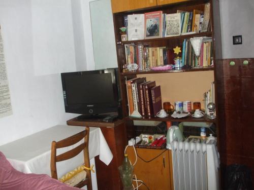 un soggiorno con una TV e una libreria di Kamigs Rooms a Sofia