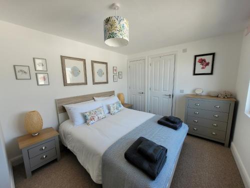 a bedroom with a bed with two nightstands and a bed sidx sidx sidx at No 28 Contemporary beach side property with sea views in Chichester
