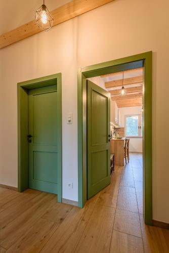 two green doors in a room with a kitchen at Dom pri jazere, Bešeňová in Bešeňová