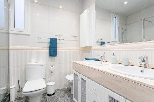 a white bathroom with a toilet and a sink at Canela Homes BARCELONA FIRA in Barcelona