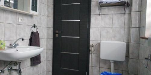 a bathroom with a black door and a sink at ⌂ Privathaus 