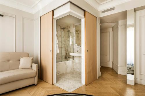 a bathroom with a shower and a couch in a room at Maison Pigalle in Paris