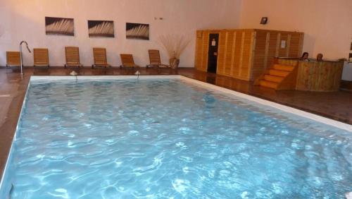 a large swimming pool in a room with chairs at Orelle 3 Vallées - 2 pièces 5/6 personnes in Orelle